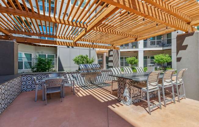 an outdoor patio with a dining table and chairs and a pergola