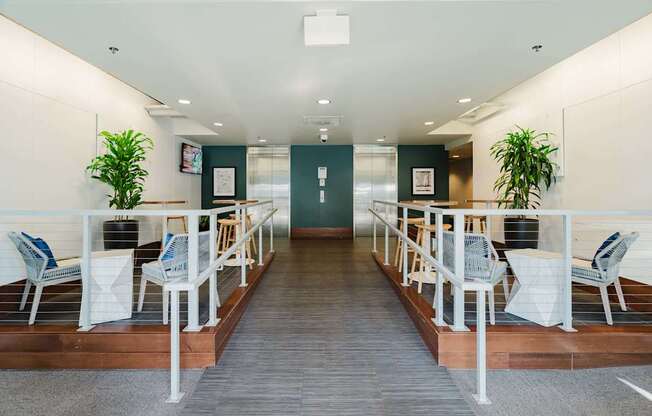 A long hallway with chairs and plants on either side.