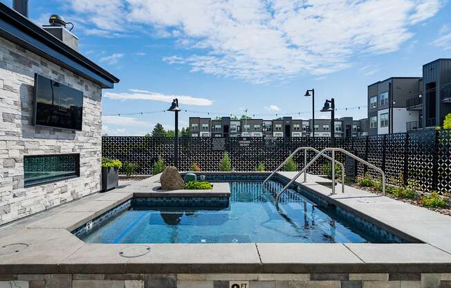 the pool is next to a building with a city in the background