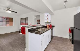 A kitchen with white cabinets and a black countertop at Urban WalkApartments on 6th Avenue, Phoenix 85016