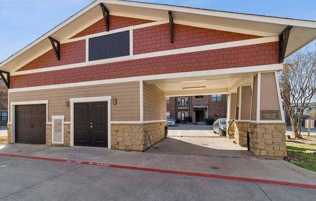 A two-story house with a red brick facade and a garage.