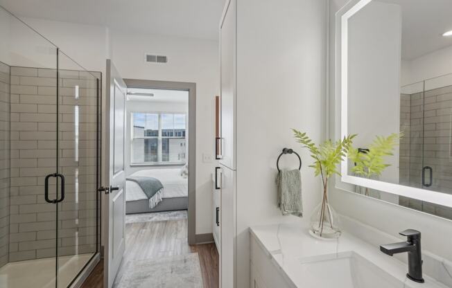 a white bathroom with a shower and a sink at Meridian at CityPlace, Woodbury, MN