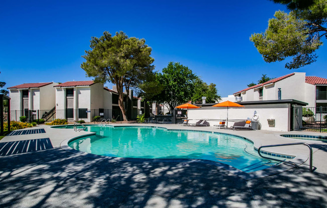 a swimming pool with trees and buildings in the background