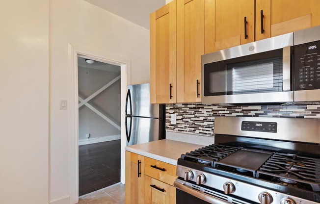 A studio apartment kitchen with a stove, microwave, and oven.