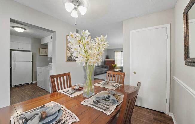 A dining room with a wooden table set for a meal.