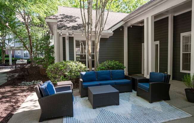 a patio with couches and chairs in front of a house