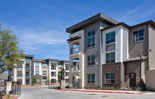 a row of apartment buildings on the side of a street at Hunters Creek Apartments, Denton, TX 76210