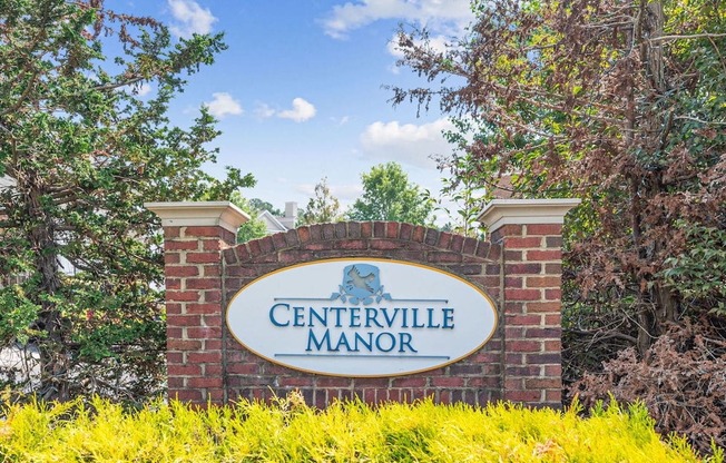 a sign that says centerville manor with trees in the background