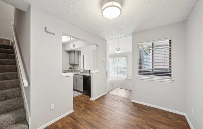 A kitchen area with a staircase on the left side.