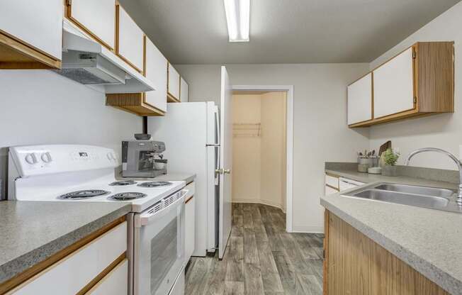 A kitchen with a white stove and a white refrigerator.