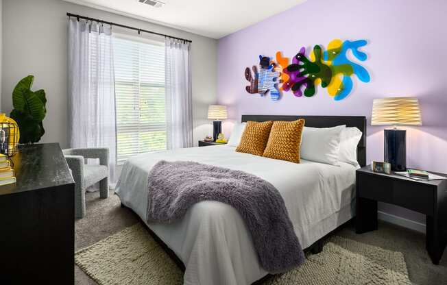 a bedroom with a large bed and a colorful painting on the wall  at Abberly Noda Vista Apartment Homes, Charlotte