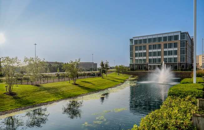a pond with a fountain in front of a building