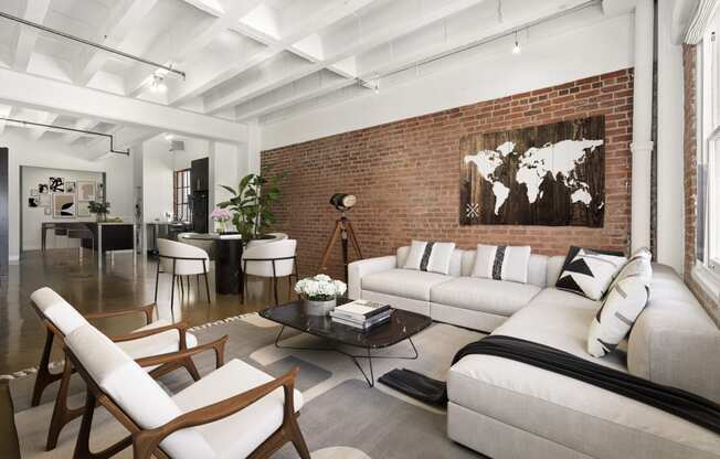 a living room with a white couch and a brick wall