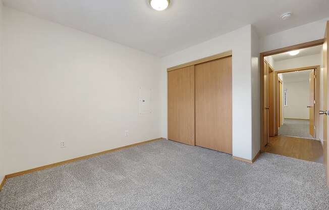 a bedroom with white walls and carpet