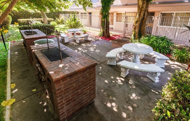 a patio with a barbecue grill and tables