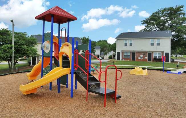 a playground with a yellow and red slide and monkey bars