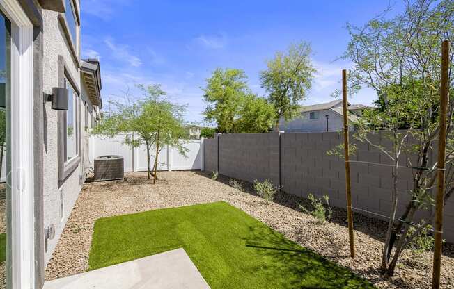 a backyard with a grassy area and a fence