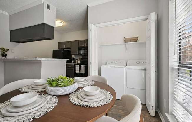 A modern kitchen with a dining table set for two.