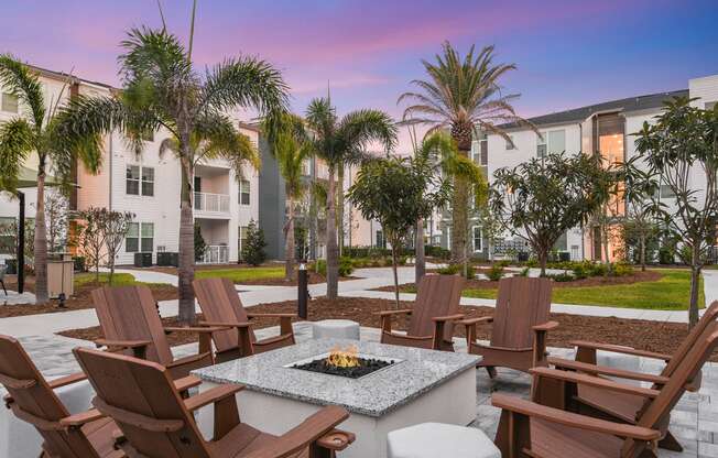 a patio with a fire pit and chairs