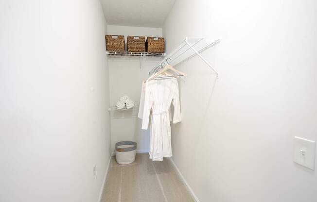 A white bathroom with a towel hanging on a rack.