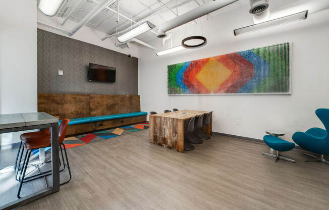 a conference room with a table and chairs and a painting on the wall