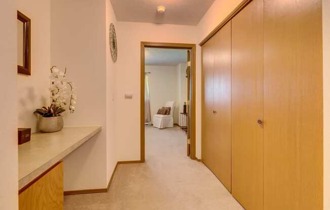 a hallway with wooden cabinets and a white carpet