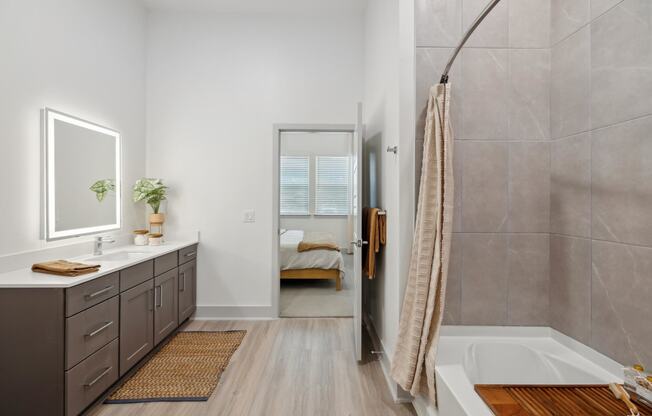 a bathroom with a tub and a shower and a sink and a mirror