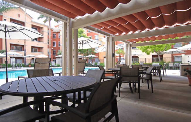 A patio with a table and chairs under a roof.