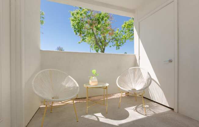 a room with two chairs and a table on a balcony