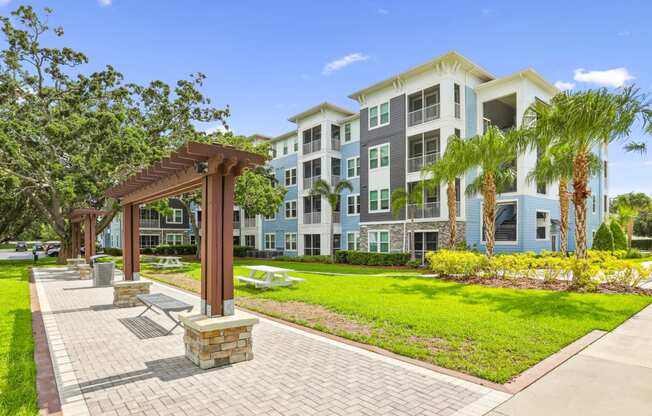 Bench seating by sidewalks and apartment buildings at Dunedin Commons apartments in Dunedin, FL