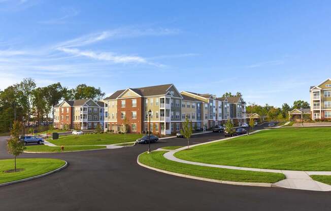 A road with a car on it and apartment buildings on both sides.