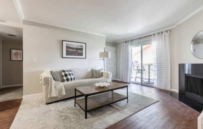 model living room with faux wood flooring, fireplace and sliding glass door to patio