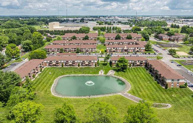 A large building complex with a green field in front.