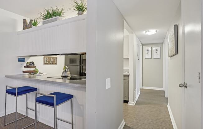 a kitchen with a bar and stools in a renovated apartment