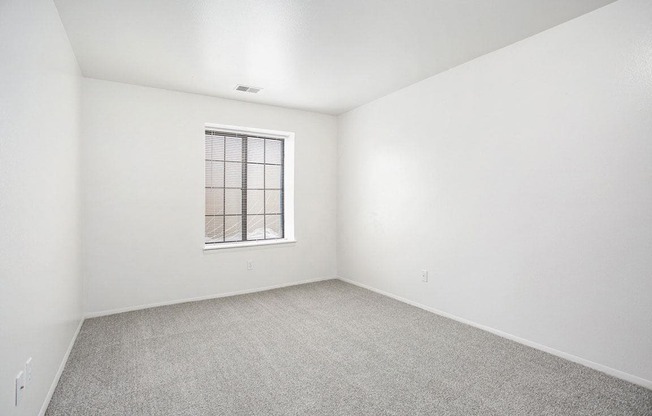 a spacious bedroom with a window at Hampton Lakes Apartments, Michigan, 49534