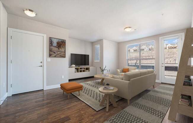 A living room with a couch, a chair, a coffee table, and a television.