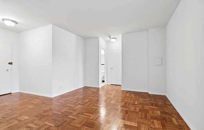 One bedroom living space with wooden flooring and white walls.