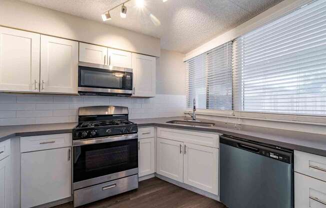 A kitchen with white cabinets and stainless steel appliances.