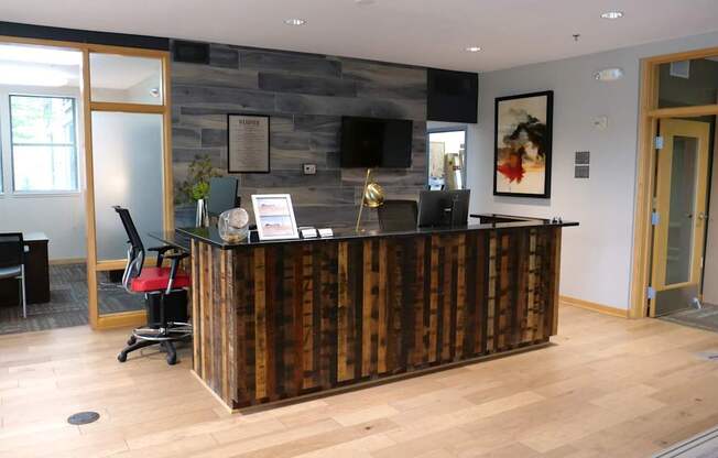 A reception area with a wooden counter and a TV mounted on the wall.