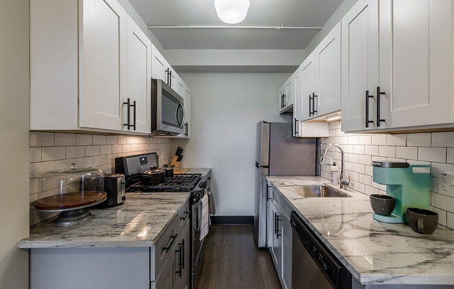 The Edison apartments kitchen with stainless appliances and white cabinetry