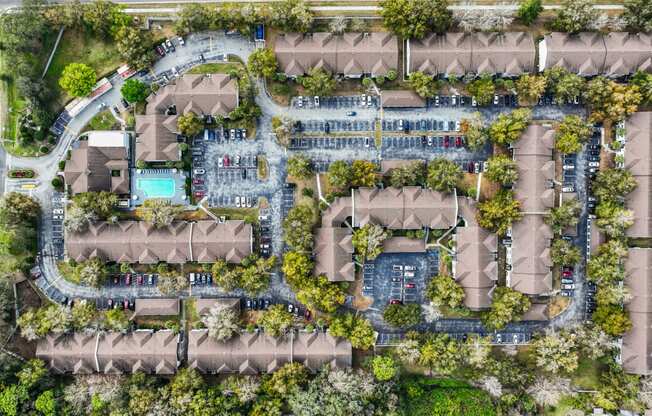 a birds eye view of a residential neighbourhood with trees and a pool