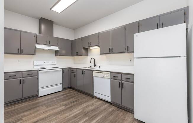 a large kitchen with white appliances and gray cabinets  at Shoreline Village, Richland, 99352