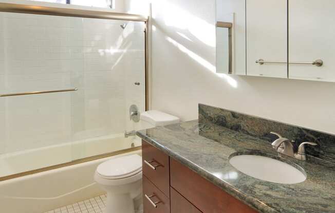 Apartment bathroom with vanity, shower tub combo