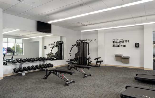 a gym with weights and other exercise equipment in the corner of a room