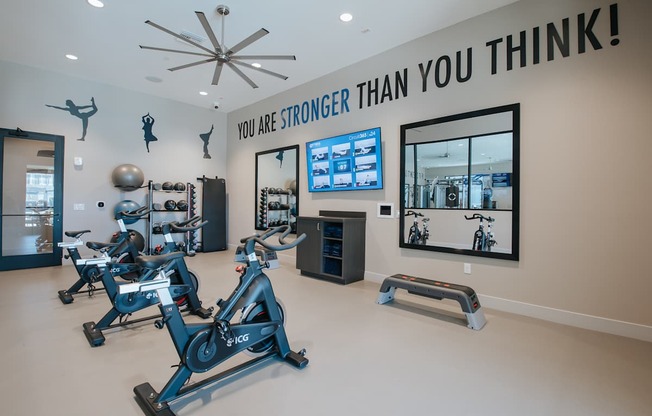 Yoga and spin room with spin bikes, TV and other equipment.