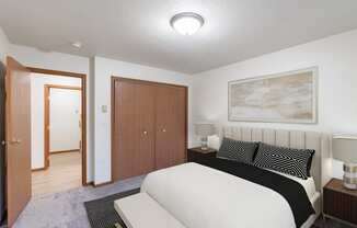 a bedroom with a bed and a closet and a door to a bathroom. Fargo, ND Flagstone Apartments