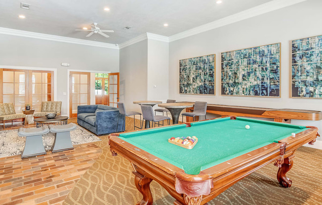 a game room with a pool table and chairs