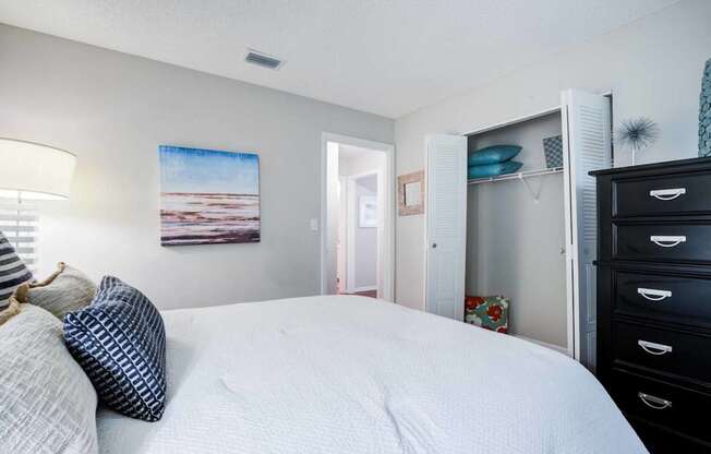 A bedroom with a large bed and a painting on the wall.