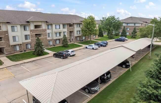 A parking lot with cars and a building in the background.