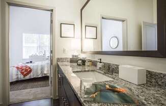 A bathroom with a sink, mirror, and a window.